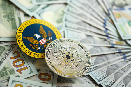 KYIV, UKRAINE - AUGUST 17, 2024 Cardano ADA coin and US Securities and Exchange Commission sign on money background close upのeditorial素材