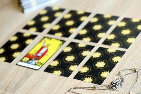 KYIV, UKRAINE - JULY 10, 2024 Tarot minor and major arcana cards of Rider Waite esoteric deck and vintage brooch with female silhouette. Many tarot cards for fortune telling and old amulet close upのeditorial素材