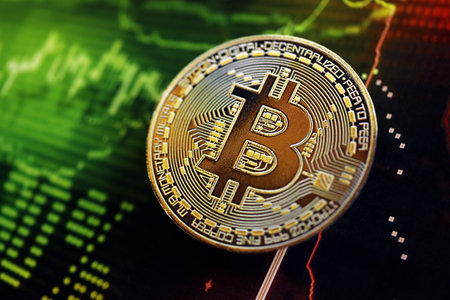 KYIV, UKRAINE - AUGUST 17, 2024 Bitcoin BTC coin on dark cryptocurrency digital trading chart in green and red colors close upのeditorial素材