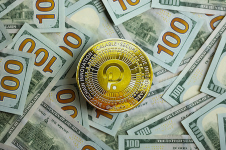 KYIV, UKRAINE - AUGUST 17, 2024 PolkaDot coin on big amount of hundred US dollar bills close upのeditorial素材