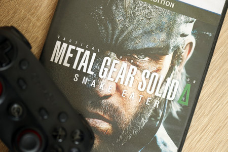 KYIV, UKRAINE - JUNE 26, 2024 Metal Gear Solid Delta Snake Eater PS5 video game disc box for console gaming. Popular video game disc close upのeditorial素材