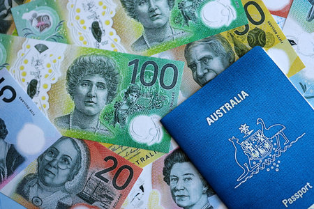 KYIV, UKRAINE - JULY 10, 2024 Australian blue travel passport and money bills of Australian currency close upのeditorial素材