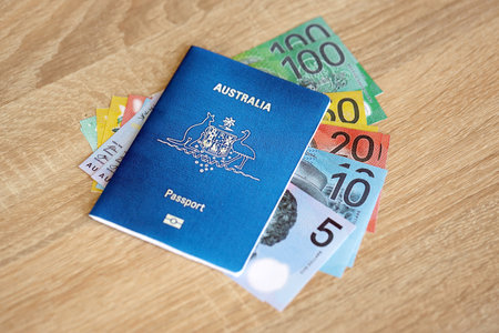 KYIV, UKRAINE - JULY 10, 2024 Australian blue travel passport and money on wooden background close upのeditorial素材