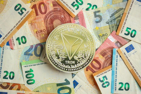 KYIV, UKRAINE - AUGUST 17, 2024 TRON Coin with big amount of european euro bills close upのeditorial素材