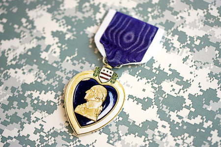 KYIV, UKRAINE - JULY 10, 2024 US Purple Heart medal. United States military award medal with ribbon and pin. Handmade paper theater props close upのeditorial素材