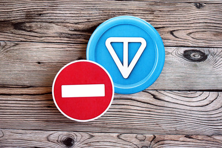 KYIV, UKRAINE - AUGUST 17, 2024 Telegram TON coin and red paper stop sign on wooden background close upのeditorial素材