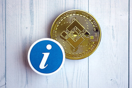 KYIV, UKRAINE - AUGUST 17, 2024 Binance BNB coin and information sign on wooden background close upのeditorial素材