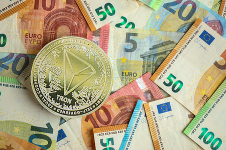 KYIV, UKRAINE - AUGUST 17, 2024 TRON Coin with big amount of european euro bills close upのeditorial素材