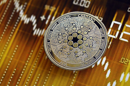 KYIV, UKRAINE - AUGUST 17, 2024 Cardano ADA coin on dark cryptocurrency digital trading chart in golden yellow colors close upのeditorial素材