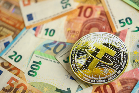 KYIV, UKRAINE - AUGUST 17, 2024 Tether USDT coin with big amount of european euro bills close upのeditorial素材