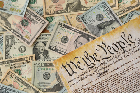 American US dollars money bills with coins and constitution close up on american flag. The American Recovery and Reinvestment Act Government Conceptの写真素材