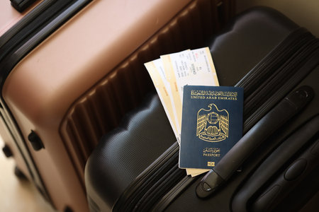 United Arab Emirates UAE passport with tickets lies on touristic suitcase close up in airport waiting hall. Travel worldwide and international tourism conceptの写真素材