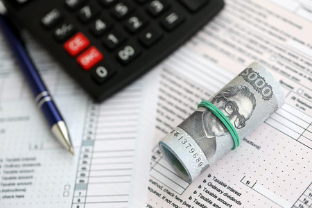 Bangladeshi taka money bills in big amount lies on table with pen, calculator and tax forms close up. Finance and banking conceptの写真素材