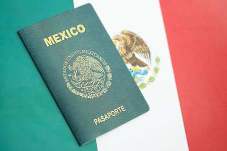 Mexican passport lies on Mexico flag close up. Travel and citizenship conceptの写真素材