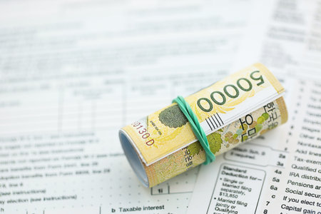 South Korean won money bills in big amount lies on table with tax forms close up. Accounting and taxation conceptの写真素材