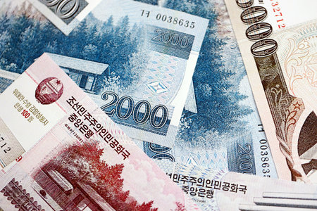 North Korean won money bills in big amount lies on white color table close up. Finance and banking conceptの写真素材