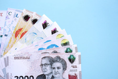 Argentine pesos money bills in big amount lies on teal color table close up. Finance and banking conceptの写真素材