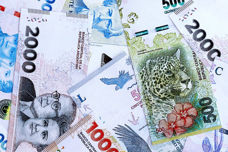 Argentine pesos money bills in big amount lies on white table close up. Finance and banking conceptの写真素材