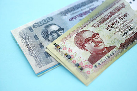 Bangladeshi taka money bills in big amount lies on teal color table close up. Finance and banking conceptの写真素材