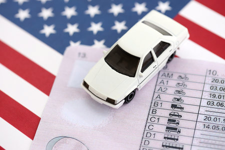 Toy car on driving license close up on United States flag. Driving license specimen card and US flagの写真素材