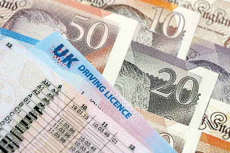 United Kingdom driving license card on UK British pounds money close up