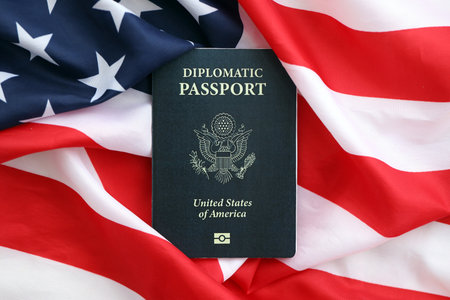 United States diplomatic passport book on US flag close up. Travel document on official banner photo