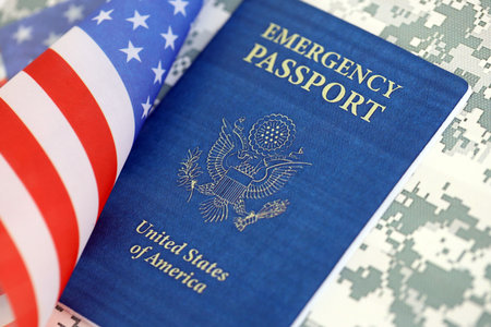 United States emergency passport book with US flag on camouflage uniform close up. Travel document on camo fabric photoの写真素材
