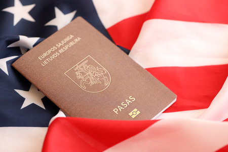 Lithuania passport on big waving flag of United States of America close up.の写真素材