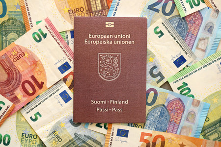 Finland passport lies on big amount of euro money banknotes close up. Rich life and travel in Europe conceptの写真素材