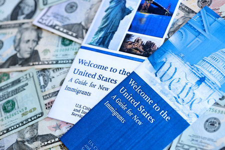 Permanent resident green card holders guide for new immigrants lies on many dollar bills close upの写真素材