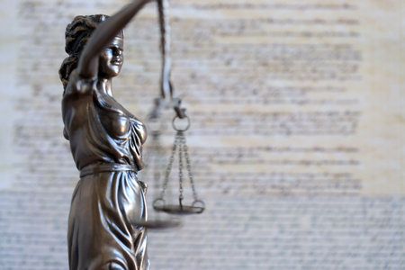 Lady Justice bronze statue and US Constitution blurred page close up. Lawsuit and punishment in United States of Americaの写真素材