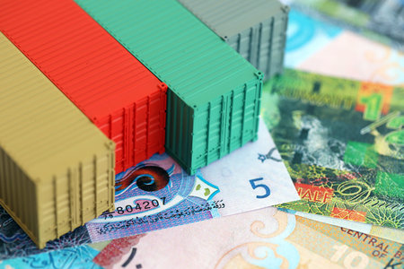 Kuwaiti dinar currency money bills and toy cargo containers close up. The concept of shipping and...
