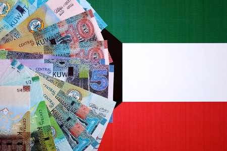 Kuwaiti dinar currency money bills lies on flag close up. The concept of business and investmentの写真素材