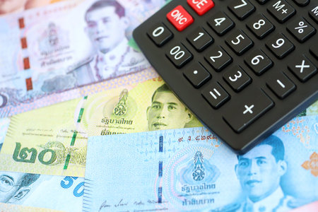 Thai baht currency money bills and calculator close up. The concept of taxation and money countの写真素材