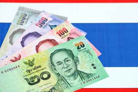 Thai baht currency money bills lies on flag close up. The concept of business and investmentの写真素材