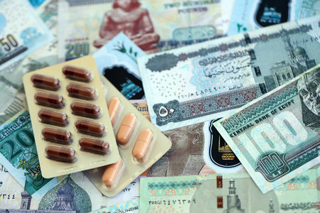 Egyptian pound currency money bills and medicine pills close up. The concept of medicine and pharmacyの写真素材