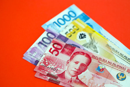Philippines peso money bills in big amount close up on red. Finance and banking conceptの写真素材