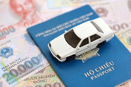 Vietnamese dong currency money bills and car with passport close up. The concept of car ownershipの写真素材