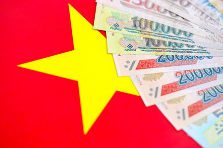 Vietnamese dong currency money bills lies on flag close up. The concept of business and investmentの写真素材