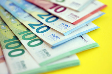 Big amount of european euro currency money notes on yellow color table close up. Concept of business and income in Europeの写真素材