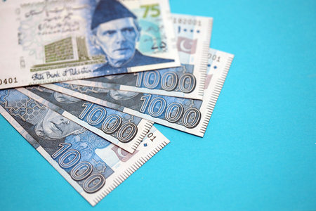 Pakistan rupees banknotes on blue background. The current Pakistan money bills lies on table in big...