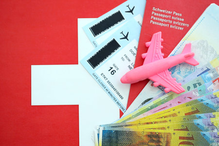 Swiss franc banknotes and passport with tickets on flag. The current francs money bills and biometrical pass lies on flag. The concept of travel and vacation in Switzerlandの写真素材