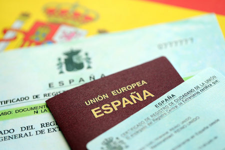 Spanish passport lies on citizenship or naturalization documents on flag of Spain close upの写真素材