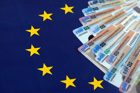 Permanent resident or residence permit cards lies on European Union flag. Specimen cards close upの写真素材