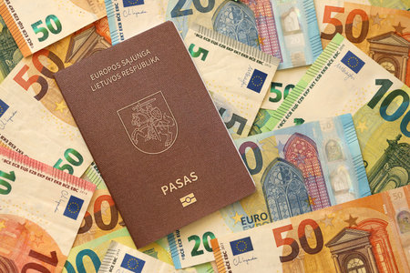 Lithuania passport lies on big amount of euro money banknotes close up. Rich life and travel in Europe conceptの写真素材