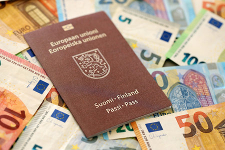 Finland passport lies on big amount of euro money banknotes close up. Rich life and travel in Europe conceptの写真素材