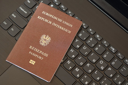 Austria passport lies on black laptop keyboard buttons background close up. Technologies and control in Europe conceptの写真素材