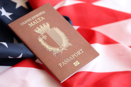 Malta passport on big waving flag of United States of America close up.の写真素材