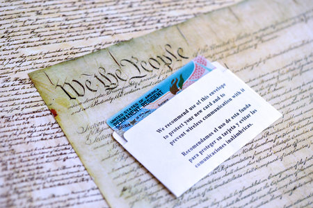Permanent resident green card in envelope lies on US constitution page close upの写真素材