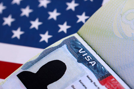 U.S. VISA United States of America. American Tourist or Green Card Visa on flag background close upの写真素材